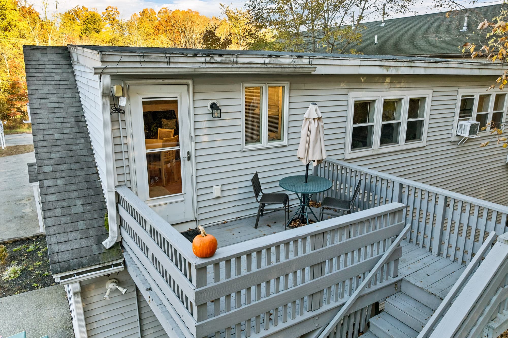 The 2-bedroom apartment's deck with a bistro table, looking back at the door and windows