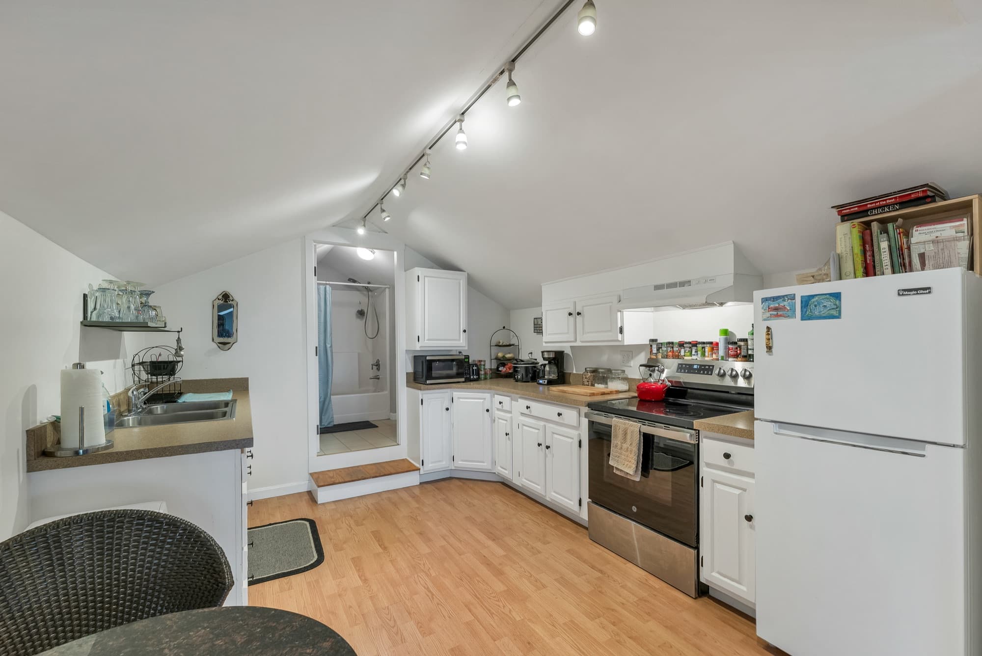 The 1-bedroom apartment's kitchen with white cabinets, a stainless range, and a round table